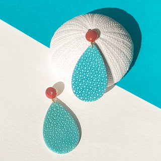 Boucles d’oreilles Acqua en galuchat turquoise, détail posé mettant en valeur la texture du galuchat, la pierre cornaline et la finition dorée à l’or fin 24 carats.