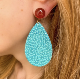 Boucles d’oreilles Acqua en galuchat turquoise zoom porté, montrant la longueur totale de 7 cm et la largeur de 3 cm, avec pierre cornaline, disponibles en percées ou clips.