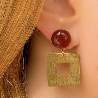 Boucles d’oreilles Arielle dépareillées dorées en cornaline et nacre blanche zoom portées côté droit, montrant l’asymétrie, les nuances naturelles des pierres et l’éclat de la dorure, disponibles en percées ou clips.