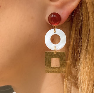 Boucles d’oreilles Arielle dépareillées dorées en cornaline et nacre blanche zoom portées gauche, montrant l’asymétrie, les nuances naturelles des pierres et l’éclat de la dorure, disponibles en percées ou clips.