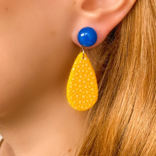 Boucles d’oreilles Gil en galuchat jaune portées, montrant la longueur totale de 5 cm et la pierre naturelle d'agate bleue, disponibles en percées ou clips.