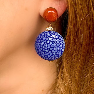 Boucles d’oreilles Grace en galuchat bleu portées, montrant la longueur totale de 4,5 cm et la largeur de 2,8 cm, avec pierre naturelle jaspe rouge, disponibles en percées ou clips.