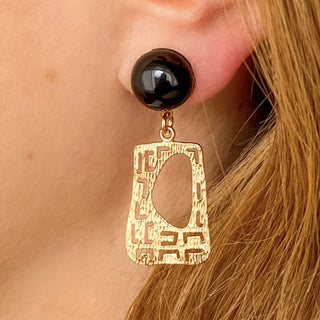 Boucles d’oreilles Gustave pendantes dorées style Art Déco en agate noire détails portés, montrant la longueur de 4 cm, les lignes géométriques et l’éclat de la dorure, disponibles en percées ou clips.