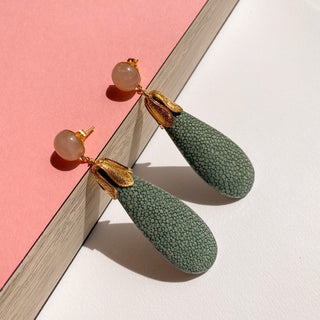 Boucles d’oreilles Jade en galuchat céladon, détail posé mettant en valeur la texture du galuchat, la pierre quartz rose et la finition dorée à l’or fin 24 carats.