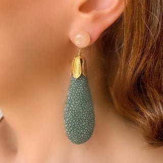 Boucles d’oreilles Jade en galuchat céladon portées, montrant la longueur totale de 8,5 cm et la largeur de 2,4 cm, avec pierre naturelle de quartz rose, disponibles en percées ou clips.