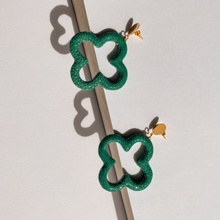Boucles d’oreilles Trèfle en galuchat vert, détail posé mettant en valeur la texture du galuchat, la forme trèfle et la finition dorée à l’or fin 24 carats
