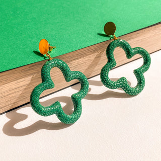 Boucles d’oreilles Trèfle en galuchat vert, zoom posé mettant en valeur la texture du galuchat, la forme trèfle et la finition dorée à l’or fin 24 carats.