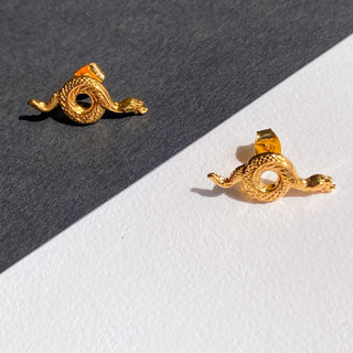 Puces d’oreilles serpent Lina dorées, détail posé mettant en valeur le motif serpent et la finition en or fin 24 carats.